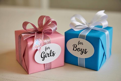 Two small gender color-coded gift boxes labeled for boys and girls. Gender stereotypes in
