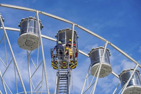Rescue workers assist in a rescue mission in a Ferris wheel cabin, fire brigade exercise for