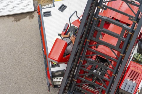 A firefighter operates the controls of a large mobile crane, fire brigade exercise for gondola