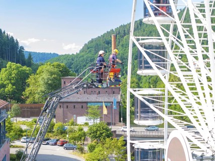 Fire brigade uses platform on Ferris wheel in a picturesque landscape, fire brigade exercise for