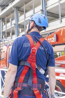 Fire brigade employee with safety equipment looking at a vehicle, fire brigade exercise for gondola