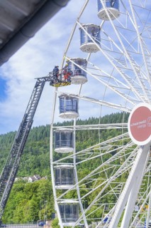 Firefighters carry out a rescue operation in a Ferris wheel standing in a green environment, Fire