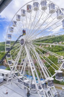 Large Ferris wheel with a view of a green landscape and houses in the background, fire brigade