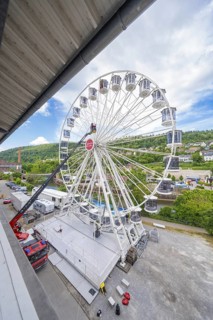 Wide angle view of a large Ferris wheel next to an urban environment, fire brigade exercise for