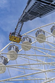 Fire brigade ladder reaches up to the Ferris wheel, ready for an operation in the clear sky, fire