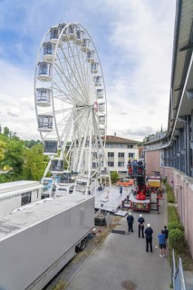 Fire brigade operation with a high Ferris wheel next to buildings with observers, fire brigade