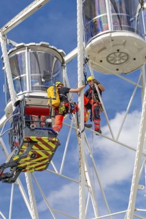 Firefighters on a rescue mission high up on a Ferris wheel, Fire brigade exercise for gondola