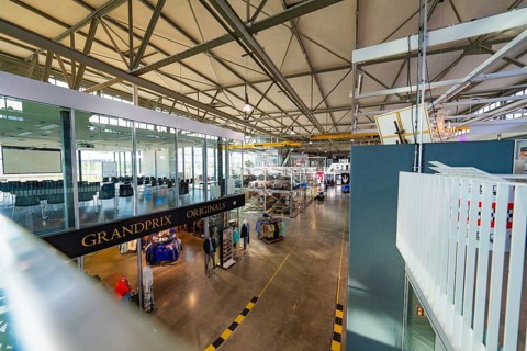 Large industrial hall with exhibited vehicles, modern architecture and bright lighting, Motorworld,