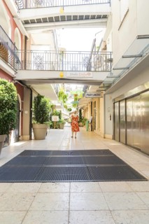 Courtyard passage with smiling woman and hanging plants, Merano, South Tyrol, Italy