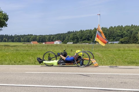 Man with handbike travelling on a country road. Special bike with manual drive for disabled people.