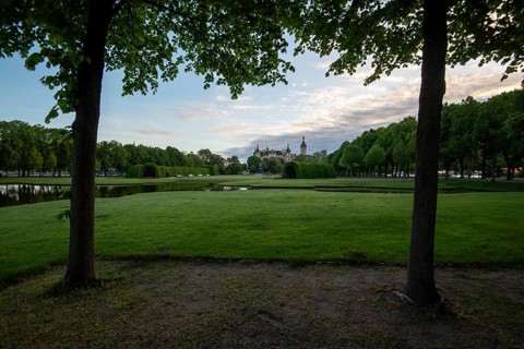 Schwerin Castle in the distance, framed by the symmetrical rows of trees in the castle garden,