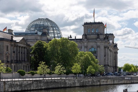 The Reichstag building in Berlin-Mitte, seat of the German Bundestag, rises imposingly behind dense