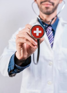 Female doctor holding stethoscope with Switzerland flag. National health system of Switzerland