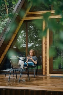 Serene moment after the rain. Pretty woman is reading something on smartphone. She is seated