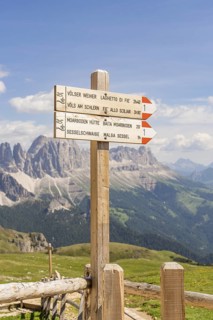 A wooden signpost points the way, the majestic mountains in the background, hike to the Schlehrn,