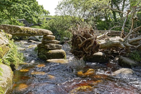 Remains of an old stone bridge and the new bridge on the East Dart River in Dartmoor National Park.