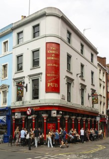 People sitting outside The Coach and Horses pub, Romilly Street, Soho, London, England, UK