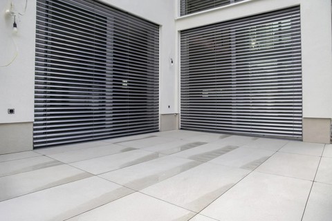 Modern terrace with large, light-coloured terrace tiles on a new detached house