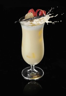 Cocktail in a highball glass on ice cube with lychee and vanilla pod as garnish against a black