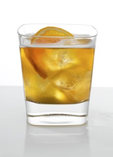 Cocktail in a tumbler on ice with half a slice of orange as garnish against a white background,