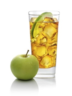Cocktail in a long drink glass on ice with half an apple slice and apple as garnish against a white