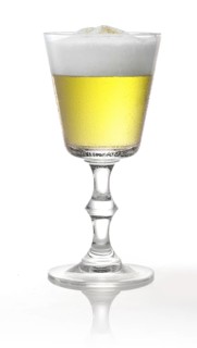 Cocktail with head of foam in a pointed goblet style glass in front of a white background, studio