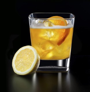 Cocktail in a tumbler on ice with half a slice of orange and half a lemon as garnish against a