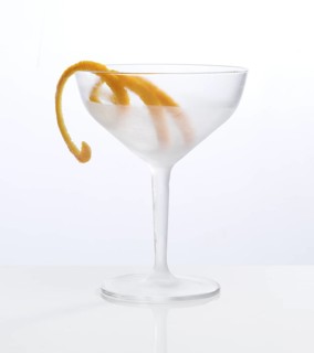 Frosted empty cocktail glass with orange zest as garnish against a white background, studio shot