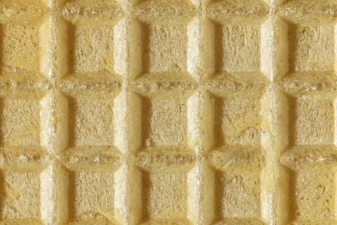 Beige, grid-like texture of a crispy wafer, macro image