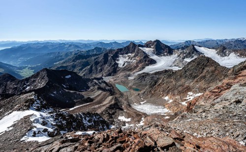 View of mountain basin with blue glacier lakes, Ãœbeltalferner glacier and Königshofspitz summit in