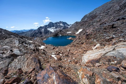 Blue glacial lake in a rocky mountain landscape, Königshofspitz in the background, descent from the