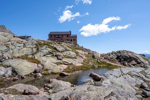 TeplitzerhÃ¼tte mountain hut and small mountain lake, Stubai Alps, South Tyrol, Italy