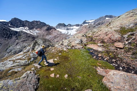 Mountaineer walking over stones, rocky mountain landscape, behind Königshofspitz, Schwarzwandspitz