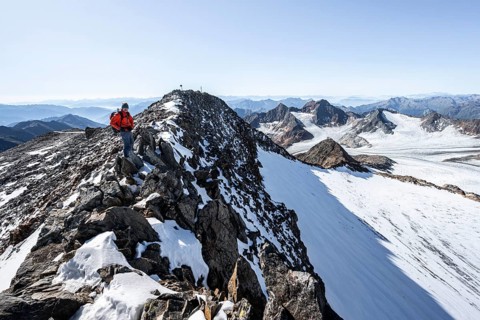 Mountaineer on narrow rocky ridge at the summit of Wilder Freiger, picturesque high mountain