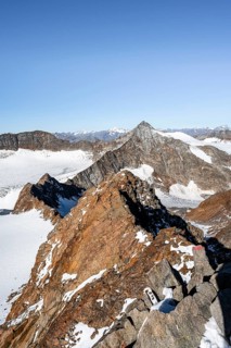 Narrow rocky ridge on the Wilder Freiger summit, picturesque high mountain landscape with snow,