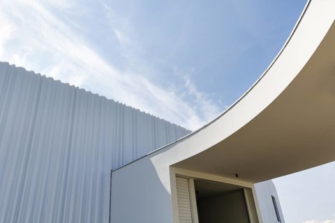 Modern white faÃ§ade made of corrugated acrylic glass, Plexiglas, SANAA production hall, architect