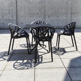 Seating area in the inner courtyard, black table and four plastic chairs, design, conference