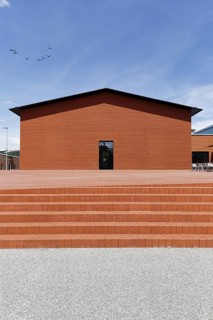 Windowless building made of red bricks in the form of a warehouse, modern architecture, architect