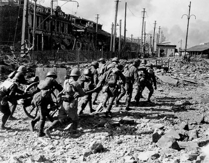 Photograph of a group of soldiers walking through destroyed Shanghai during the Second
