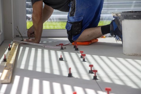 Tiler lays new floor tiles