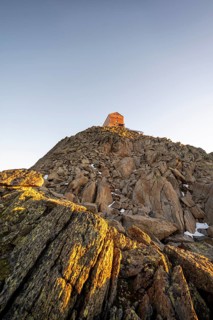 Stony summit of the Becher with mountain hut Becherhaus in the morning light at sunrise, Stubai