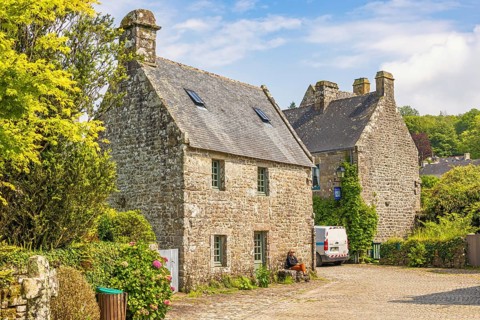 Idyllic old french village with stone houses and cobblestone streets and lush green trees a sunny