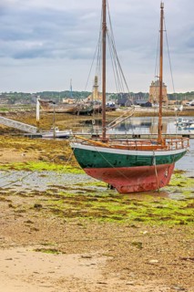 Old wooden sailboat on the shore at low tide on the coast, Camaret-sur-Mer, Crozon Peninsula,