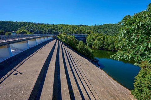 Oblique view of a dam with water reservoir surrounded by forest landscape, summer, Urft dam wall,