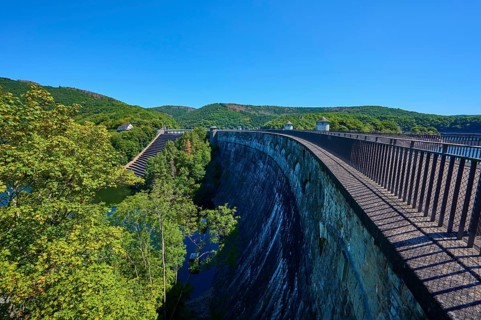 High view of a large dam with neighbouring forest and clear sky, summer, Urft dam wall, Obersee,