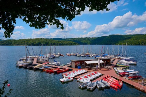 Boats and pedal boats on a jetty in a natural lake environment, summer, Rursee, Rurtalsperre,