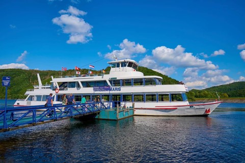 Passenger ship lying at a jetty on a lake with a deep blue sky and fleecy clouds, summer, Rursee,