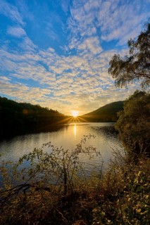 Sunset over a lake, dramatic cloud formations and golden light on the water, summer, Rursee,