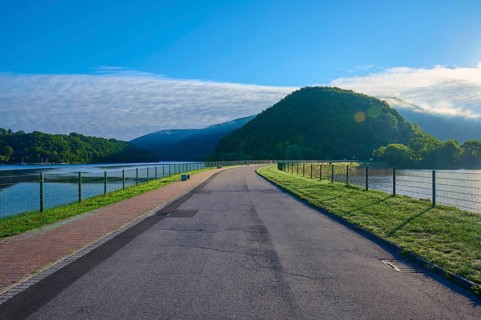 Paulushof barrier dam, dam road along a lake in a mountainous landscape, morning light and clear