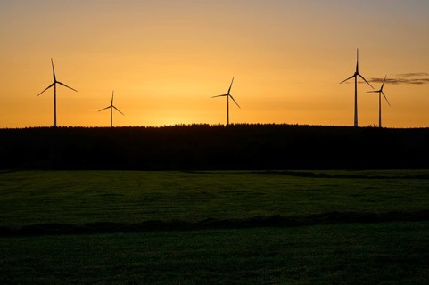 Silhouette of wind turbines at sunrise, over a green field, summer, Rohren, Monschau, Eifel, North